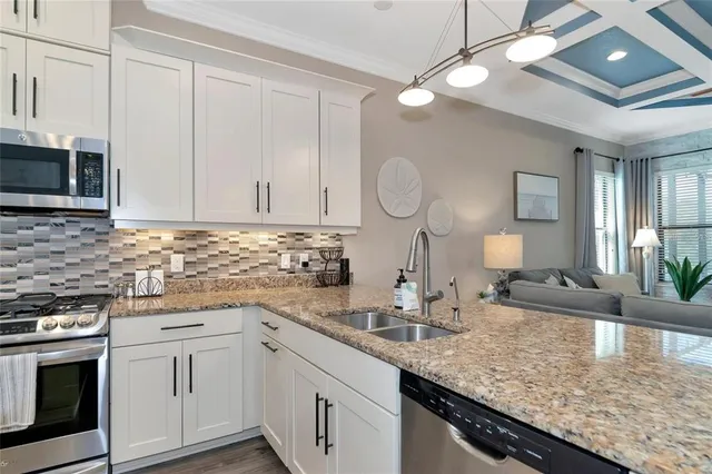 a kitchen with granite countertop a sink a stove and cabinets