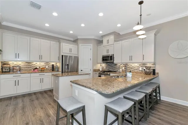 a kitchen with kitchen island granite countertop a center island a sink cabinets and stainless steel appliances