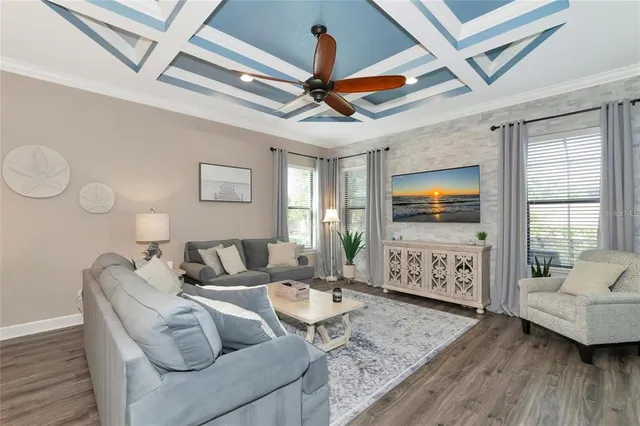 a living room with furniture a flat screen tv and a wooden floor