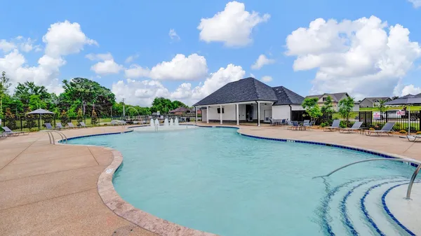 a view of a swimming pool with a yard and a porch