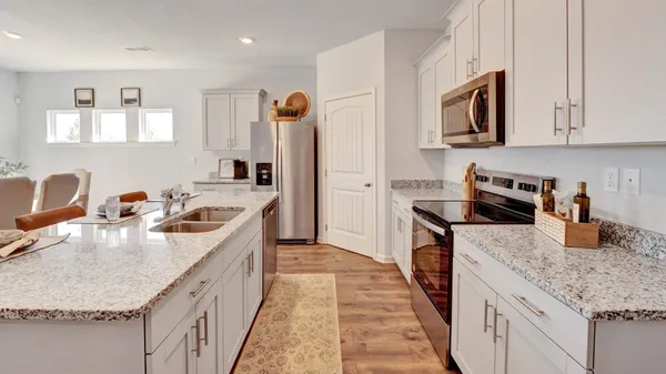 a kitchen with granite countertop a sink stove and refrigerator