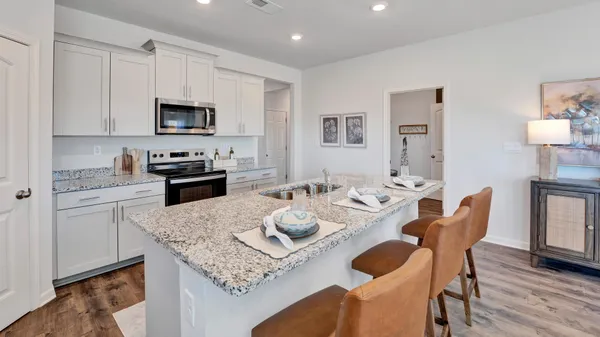 a kitchen with granite countertop white cabinets and stainless steel appliances