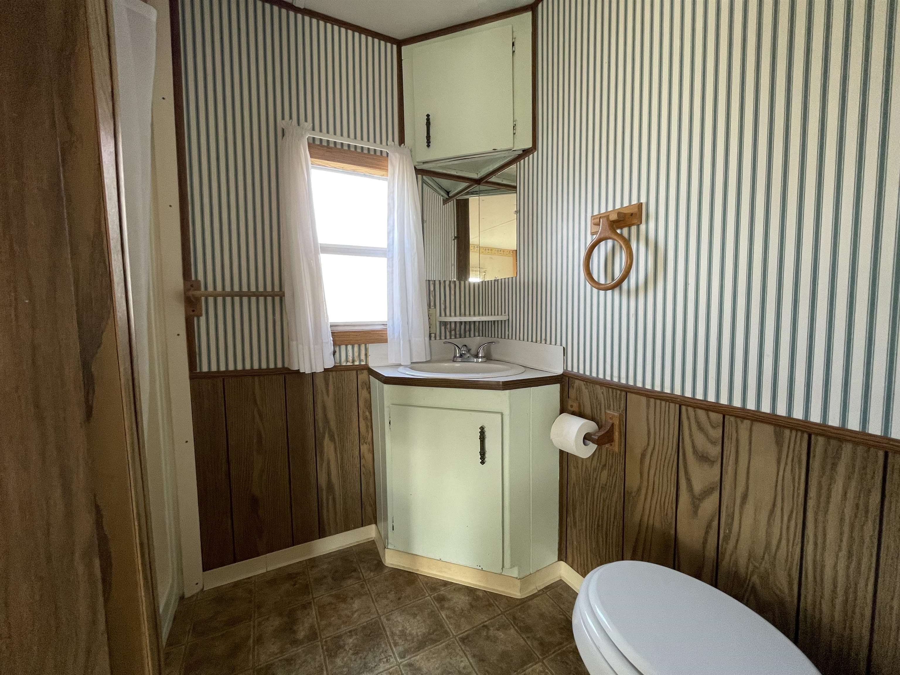 3251 E Road, Unit 102 Clifton, CO 81520 - Photo 12 of 14 a bathroom with a toilet a sink and mirror