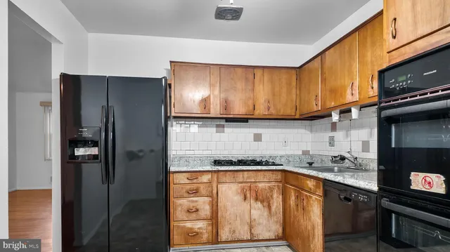 a kitchen with stainless steel appliances granite countertop a refrigerator and a sink