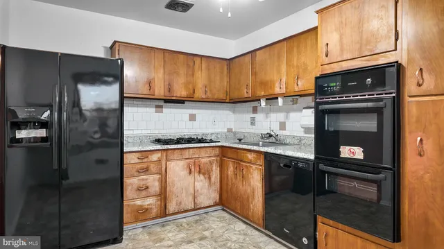 a kitchen with granite countertop a refrigerator stove and sink