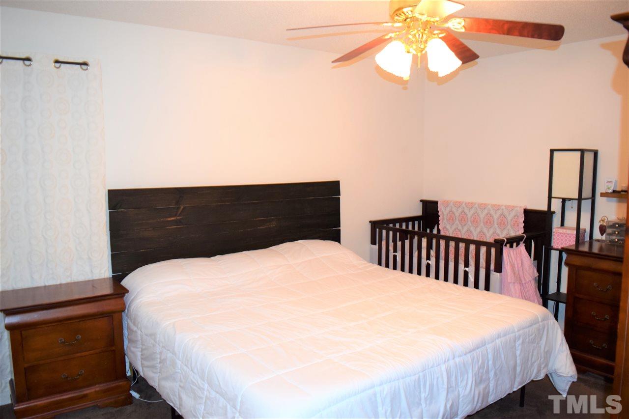 3917 Howard Circle Raleigh, NC 27604 - Photo 11 of 16 a large bed sitting in a bedroom with a chandelier