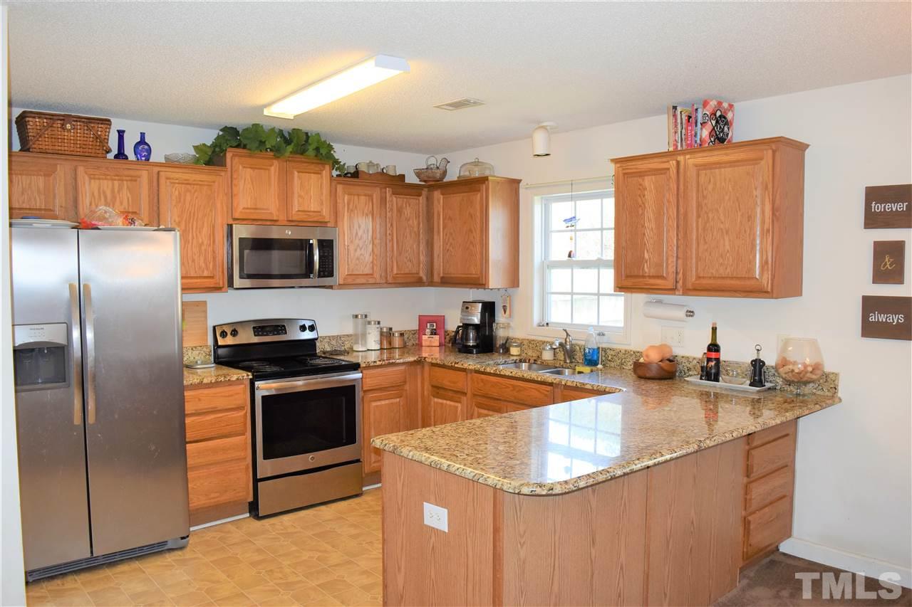 3917 Howard Circle Raleigh, NC 27604 - Photo 6 of 16 a kitchen with stainless steel appliances granite countertop a sink stove refrigerator and microwave