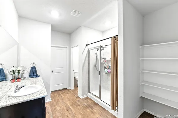 a bathroom with a granite countertop sink mirror and shower