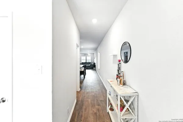 a hallway with table and a mirror