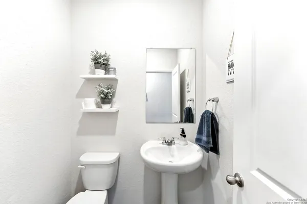 a bathroom with a toilet sink and mirror