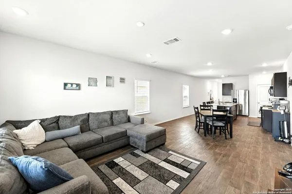 a living room with furniture and view of kitchen