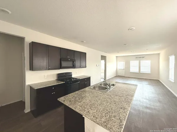 a kitchen with sink stove microwave and refrigerator