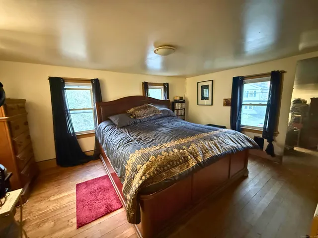 a bedroom with a bed dresser and a window
