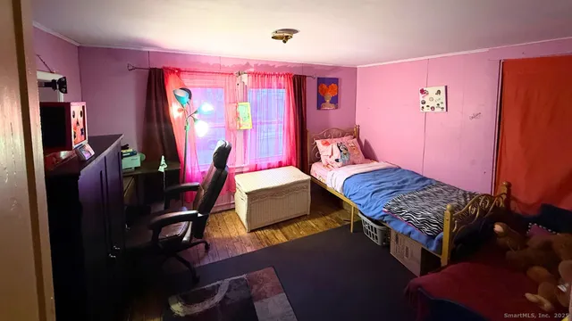 a bedroom with a bed and wooden floor