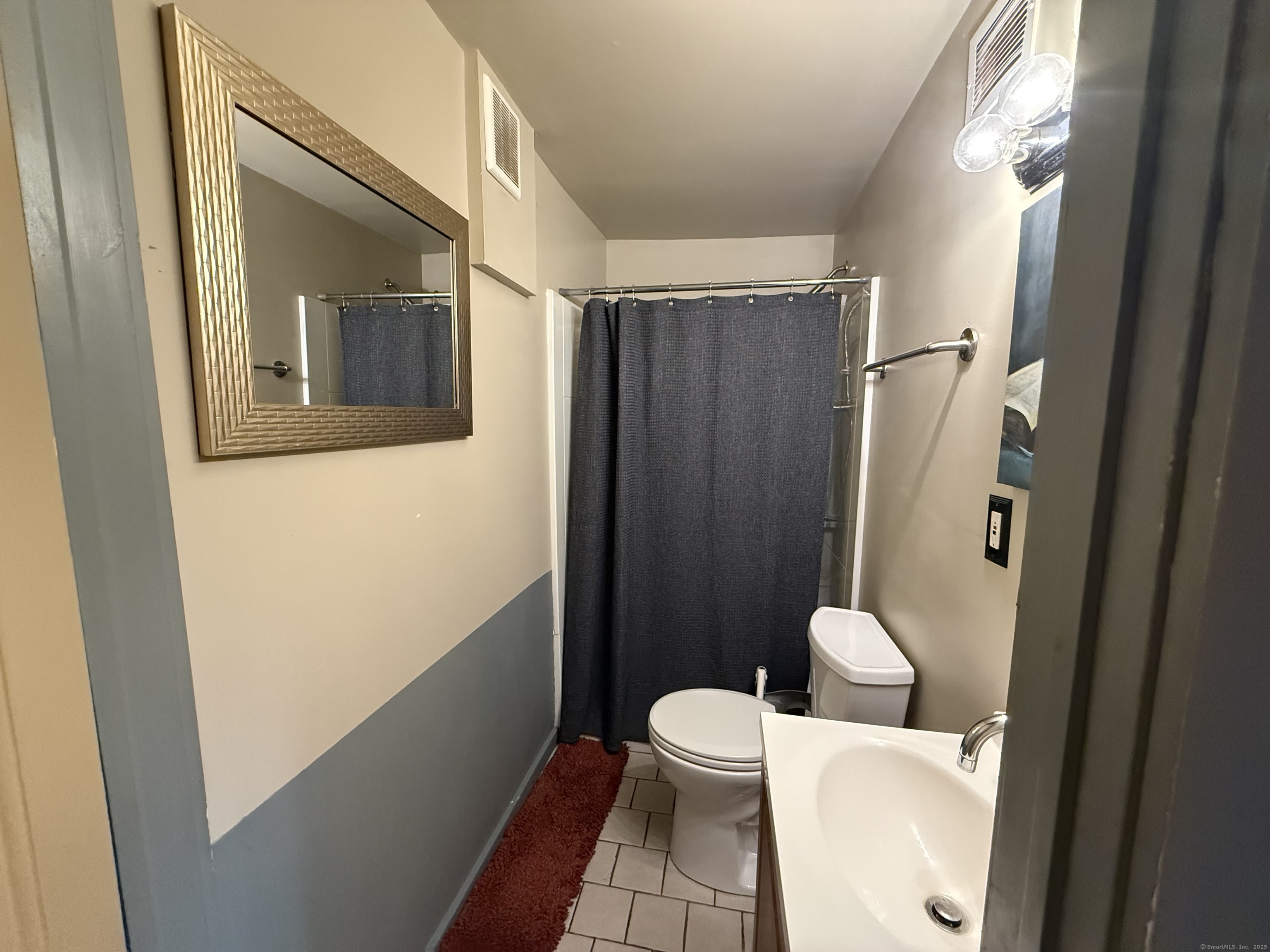 57 Austin Street New Haven, CT 06515 - Photo 6 of 18 a white toilet sitting next to a bathroom sink and a shower