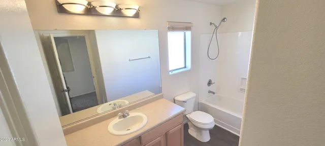 a bathroom with a granite countertop toilet sink and mirror