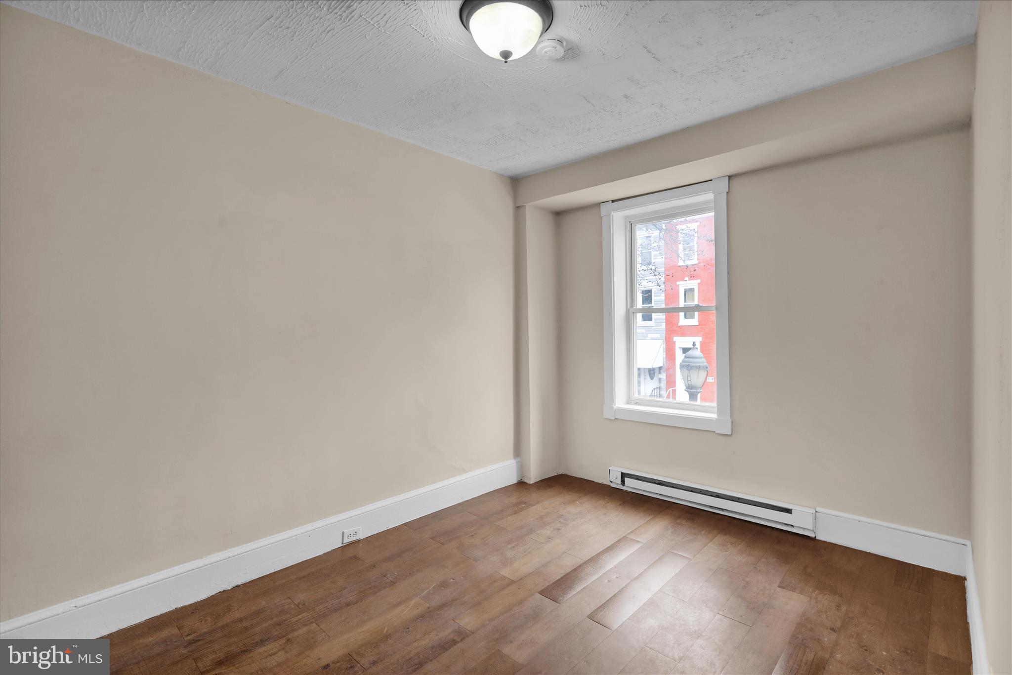 230 South 4th Street Reading, PA 19602 - Photo 12 of 26 an empty room with wooden floor and windows