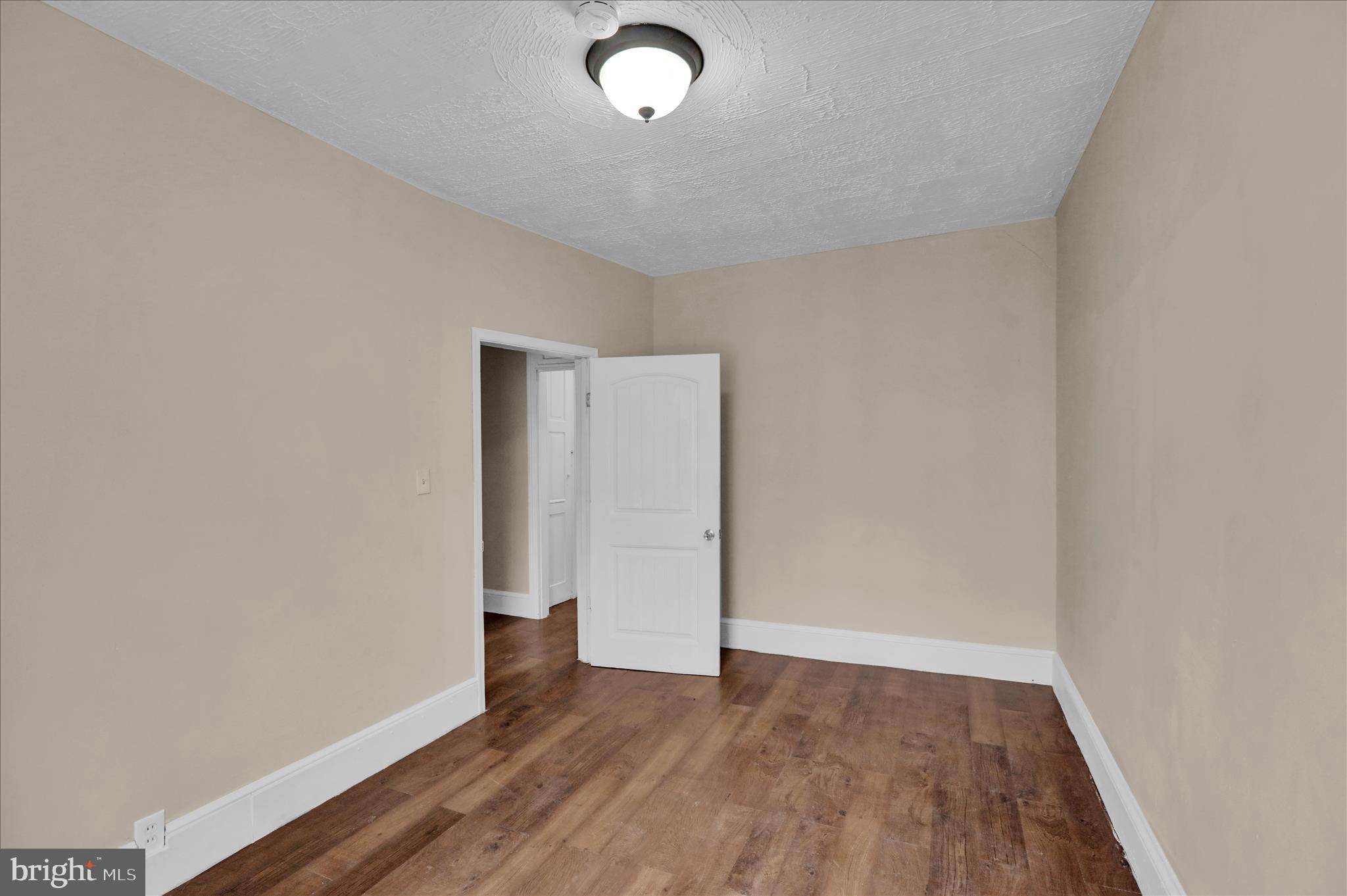 230 South 4th Street Reading, PA 19602 - Photo 13 of 26 an empty room with wooden floor and cabinets