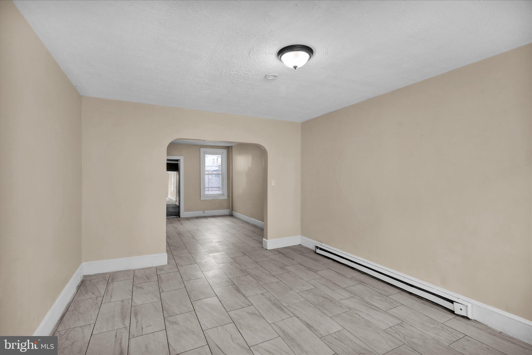 230 South 4th Street Reading, PA 19602 - Photo 3 of 26 an empty room with wooden floor and windows