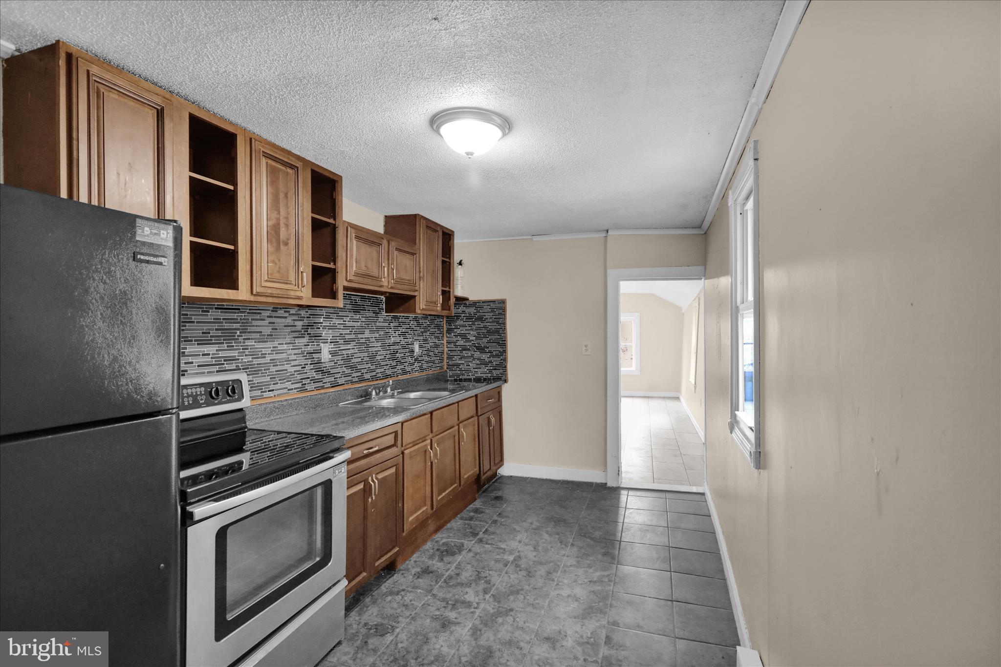230 South 4th Street Reading, PA 19602 - Photo 6 of 26 a kitchen with stainless steel appliances granite countertop a refrigerator and a sink