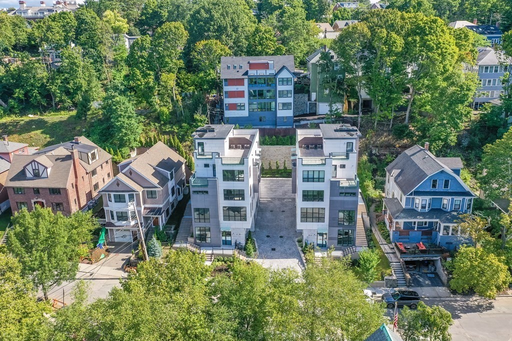 aerial view of a house with a yard and large trees