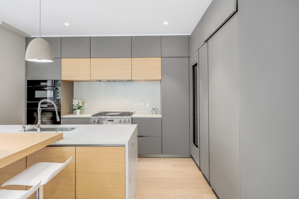 75 Westbourne Terrace, Unit 75 Brookline, MA 02446 - Photo 9 of 31 a kitchen with a sink a stove and cabinets