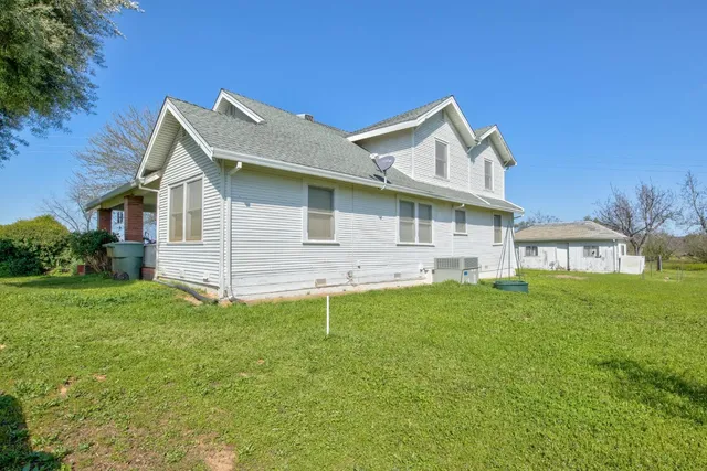 a backyard of a house with bicycles parked and swing