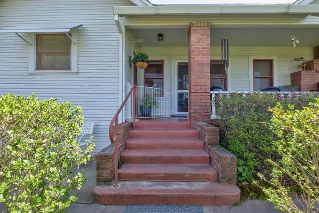 a living room with furniture a chandelier and a dining table