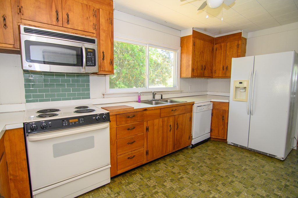 24432 Maxwell Street Parksley, VA 23421 - Photo 6 of 39 a kitchen with a stove a sink and a microwave