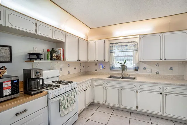 a kitchen with cabinets appliances a sink and a counter top space
