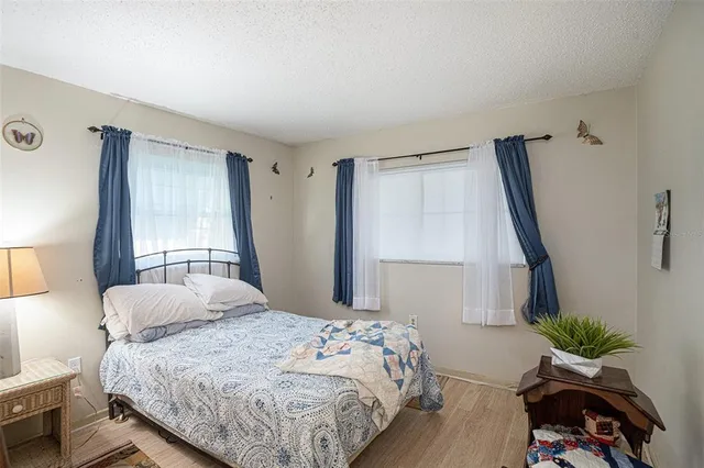 a bedroom with a bed windows and a potted plant