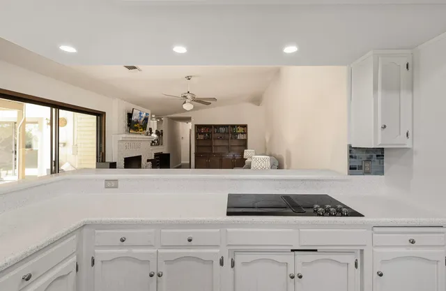 a kitchen with granite countertop white cabinets and white appliances