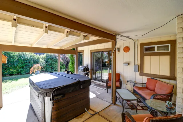 a view of a patio with table and chairs under an umbrella