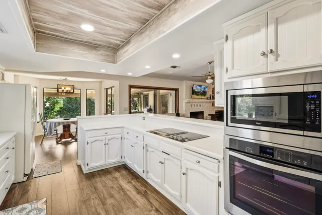 a kitchen with stainless steel appliances granite countertop a stove and white cabinets