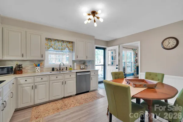 a dining room with furniture a chandelier and wooden floor