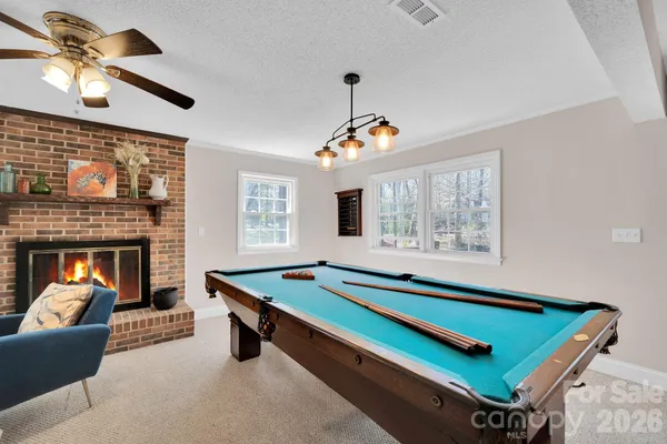 a living room with furniture pool table and a fireplace