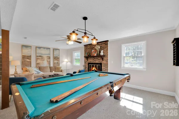 a room with pool table and windows
