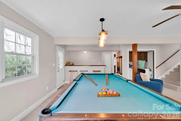 a room with pool table and windows