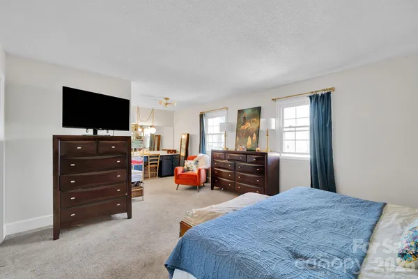 a bedroom with furniture and a flat screen tv