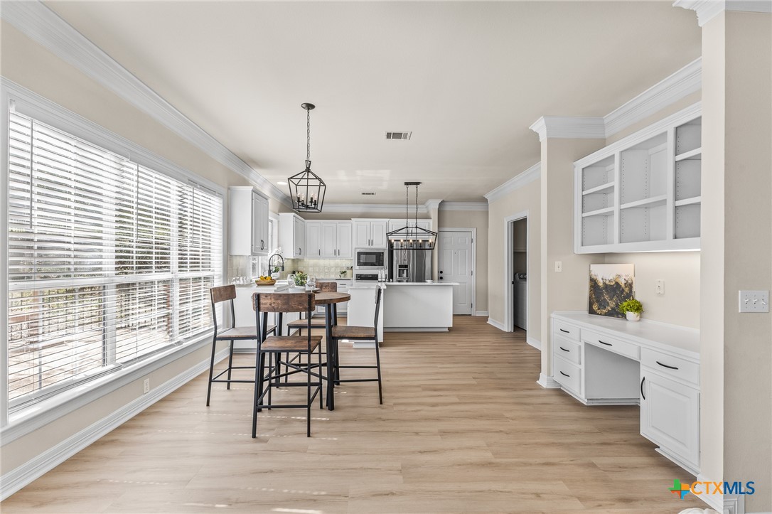 5901 Round Table Cove Austin, TX 78746 - Photo 11 of 46 a view of a dining room with furniture window and wooden floor