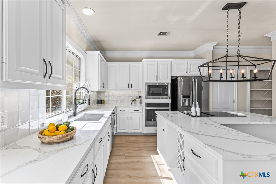 5901 Round Table Cove Austin, TX 78746 - Photo 18 of 46 a kitchen with refrigerator and stove