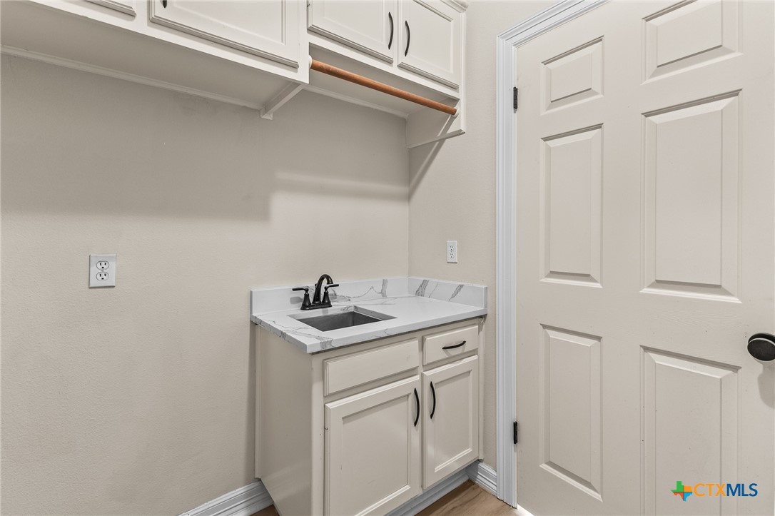 5901 Round Table Cove Austin, TX 78746 - Photo 22 of 46 a kitchen with white cabinets and white appliances