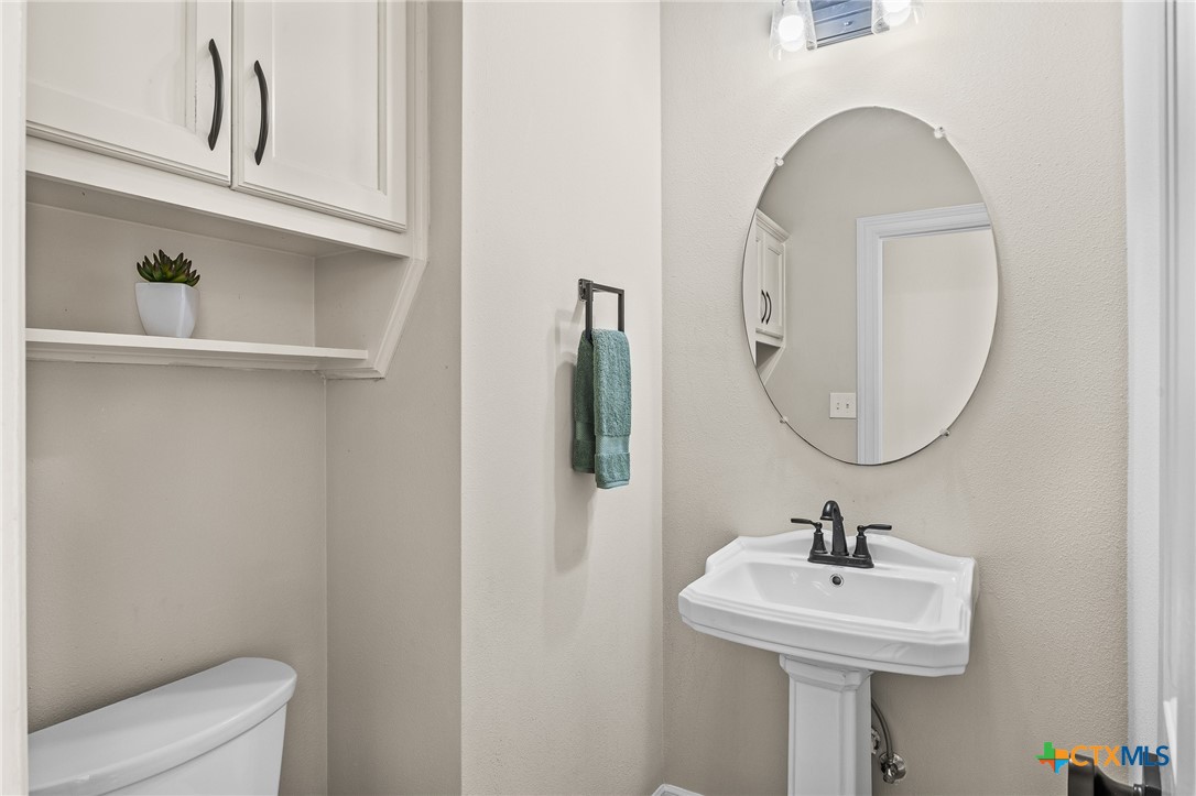 5901 Round Table Cove Austin, TX 78746 - Photo 23 of 46 a bathroom with a sink a mirror and toilet