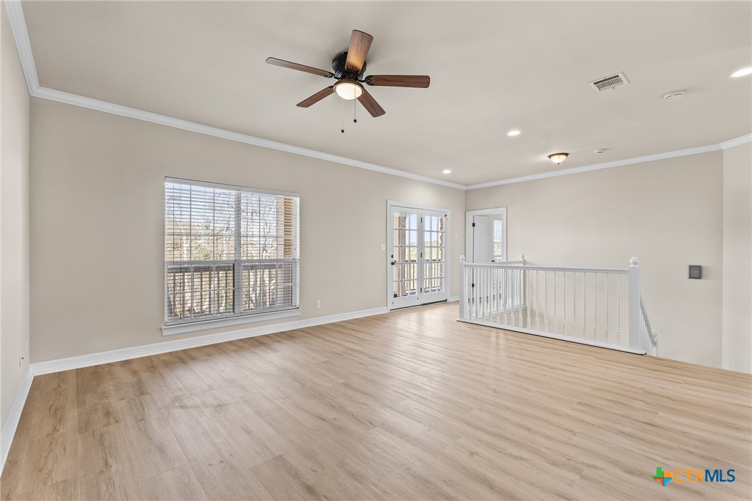 5901 Round Table Cove Austin, TX 78746 - Photo 25 of 46 a view of an empty room with a window and wooden floor
