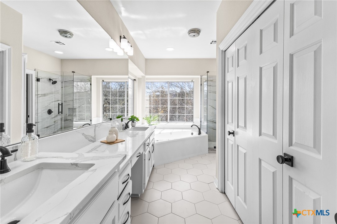 5901 Round Table Cove Austin, TX 78746 - Photo 31 of 46 a spacious bathroom with a tub sink and mirror