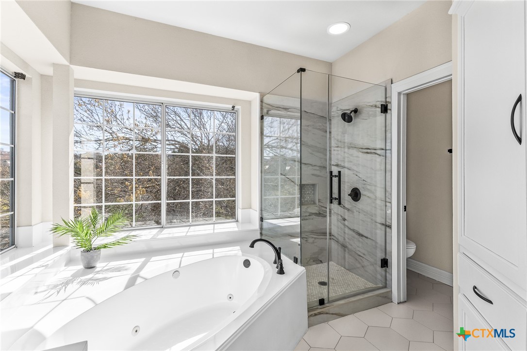 5901 Round Table Cove Austin, TX 78746 - Photo 33 of 46 a bathroom with a granite countertop tub shower and sink