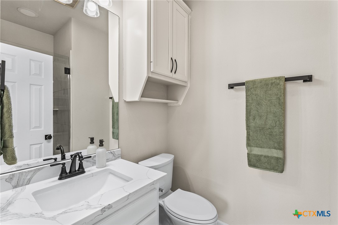 5901 Round Table Cove Austin, TX 78746 - Photo 37 of 46 a bathroom with a sink a toilet and shower curtain