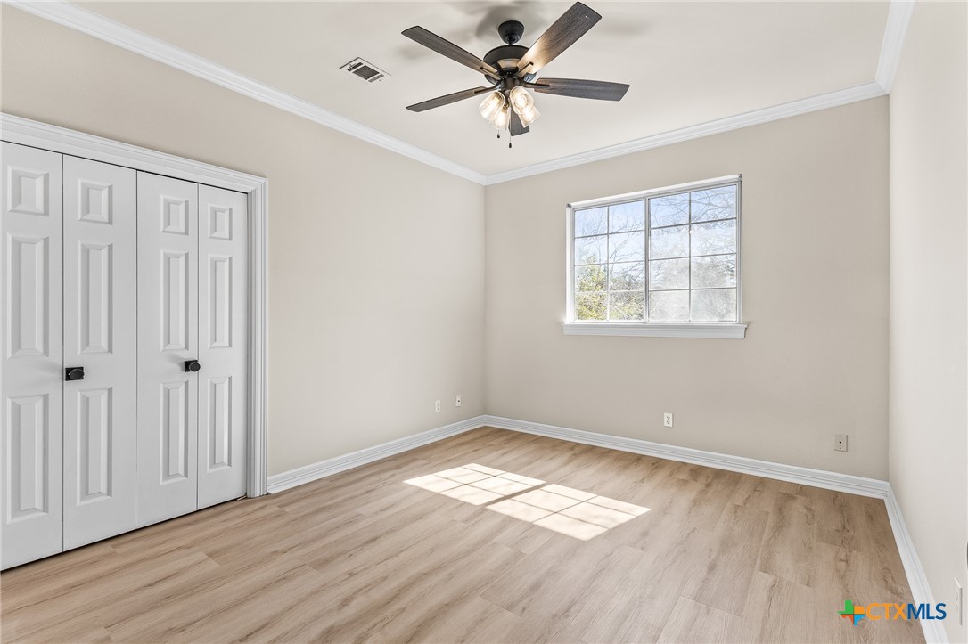 5901 Round Table Cove Austin, TX 78746 - Photo 39 of 46 a view of empty room with wooden floor and fan