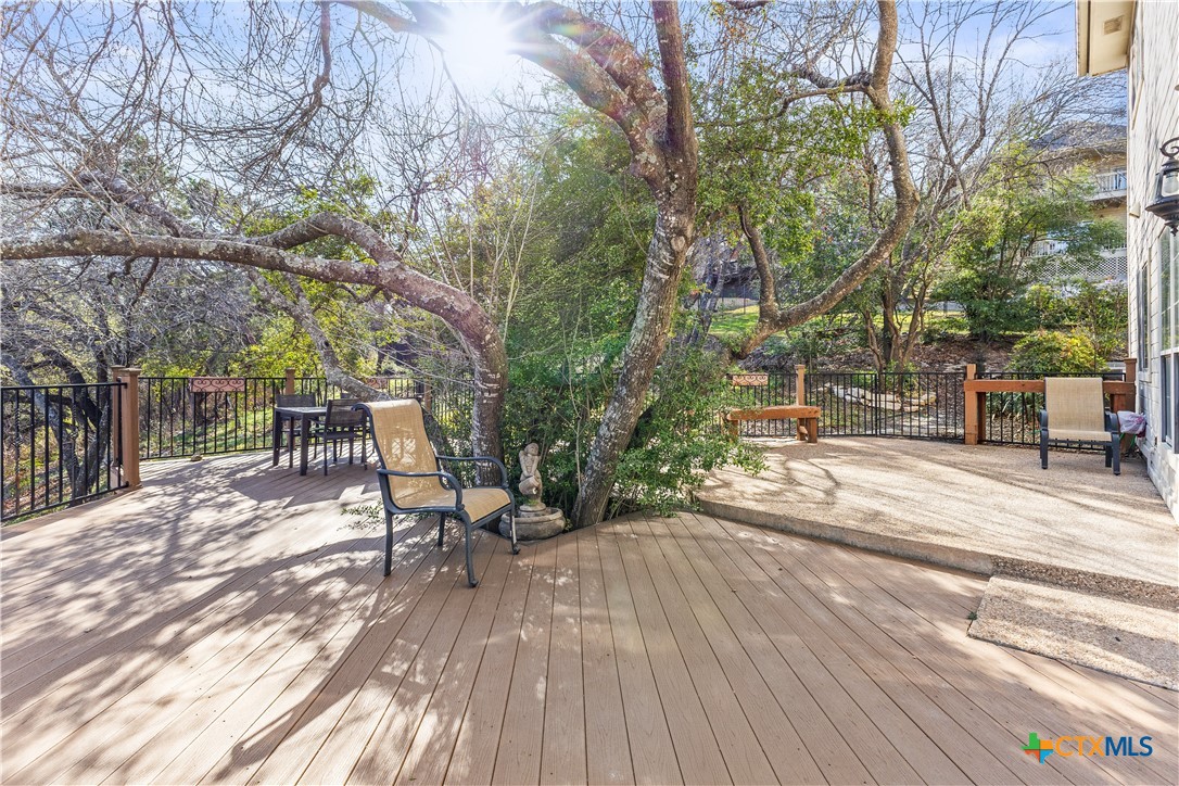 5901 Round Table Cove Austin, TX 78746 - Photo 45 of 46 a view of a patio with table and chairs with wooden floor and fence