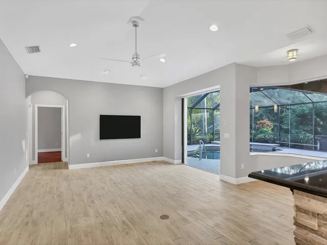a view of an empty room with a window and a kitchen
